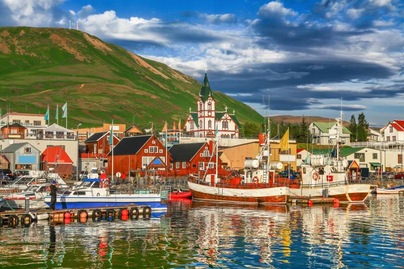 Papermoon Fototapete »HUSAVIK ISLAND-BOOTE GEBIRGE DORF STEG BRÜCKE WALD BERG« von Papermoon