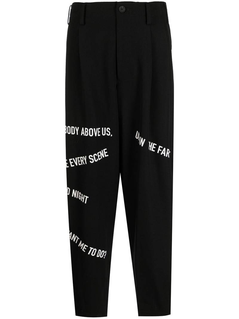 Yohji Yamamoto slogan-print dropped-crotch trousers - Black von Yohji Yamamoto